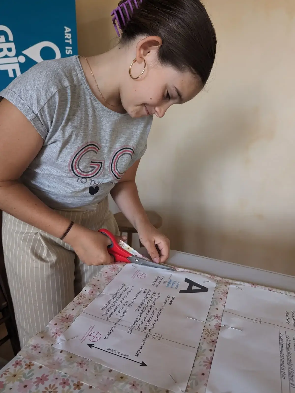 Atelier de couture avec ado qui coupe du tissu